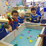Children playing with fishing poles in sensory table.