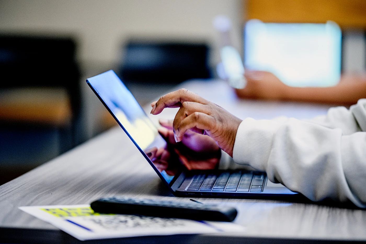 Hands using a laptop during a learning session, representing faculty and staff exploring artificial intelligence tools at SLCC.