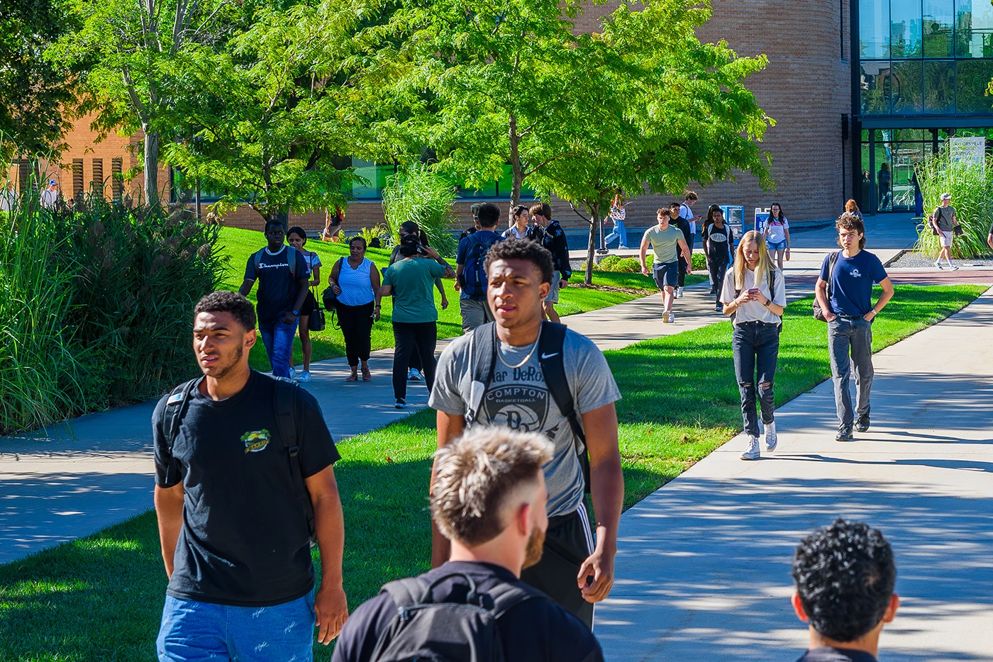 A group of students walk through the SLCC Taylorsville Campus on a sunny day.
