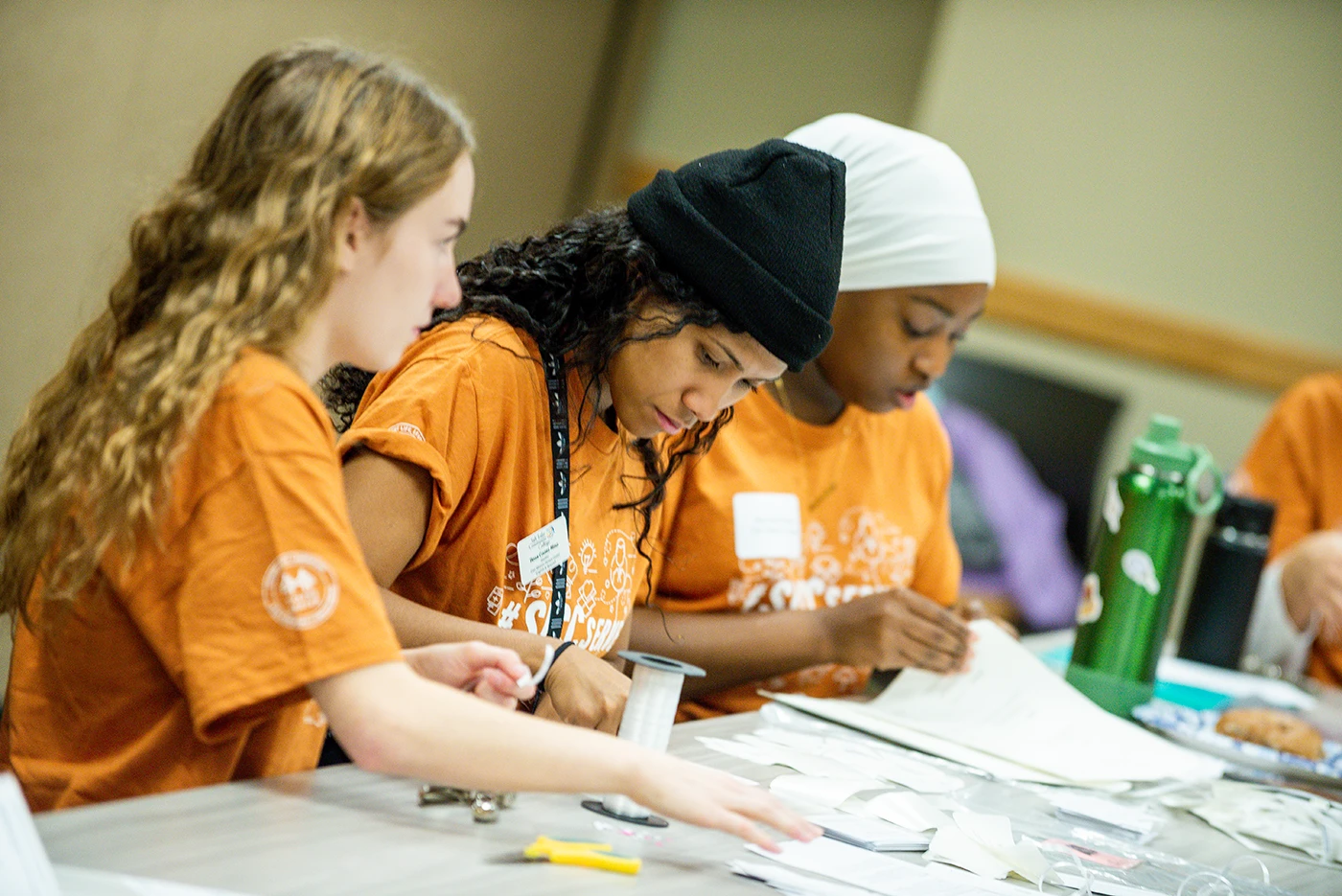 Three students of different ethnicities working together at a table.