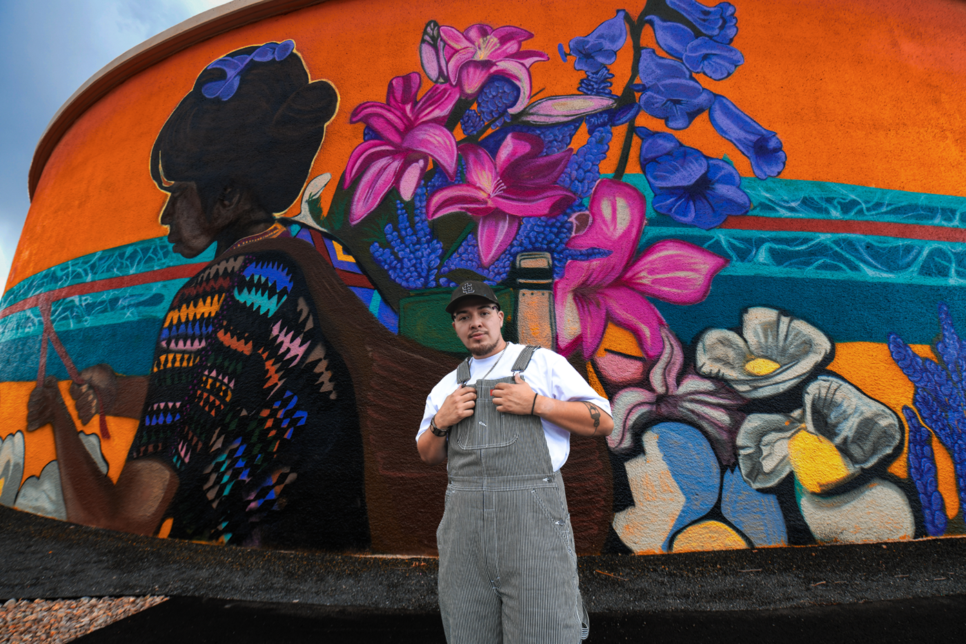 Beto Conejo in front of the mural he painted about the importance of water.