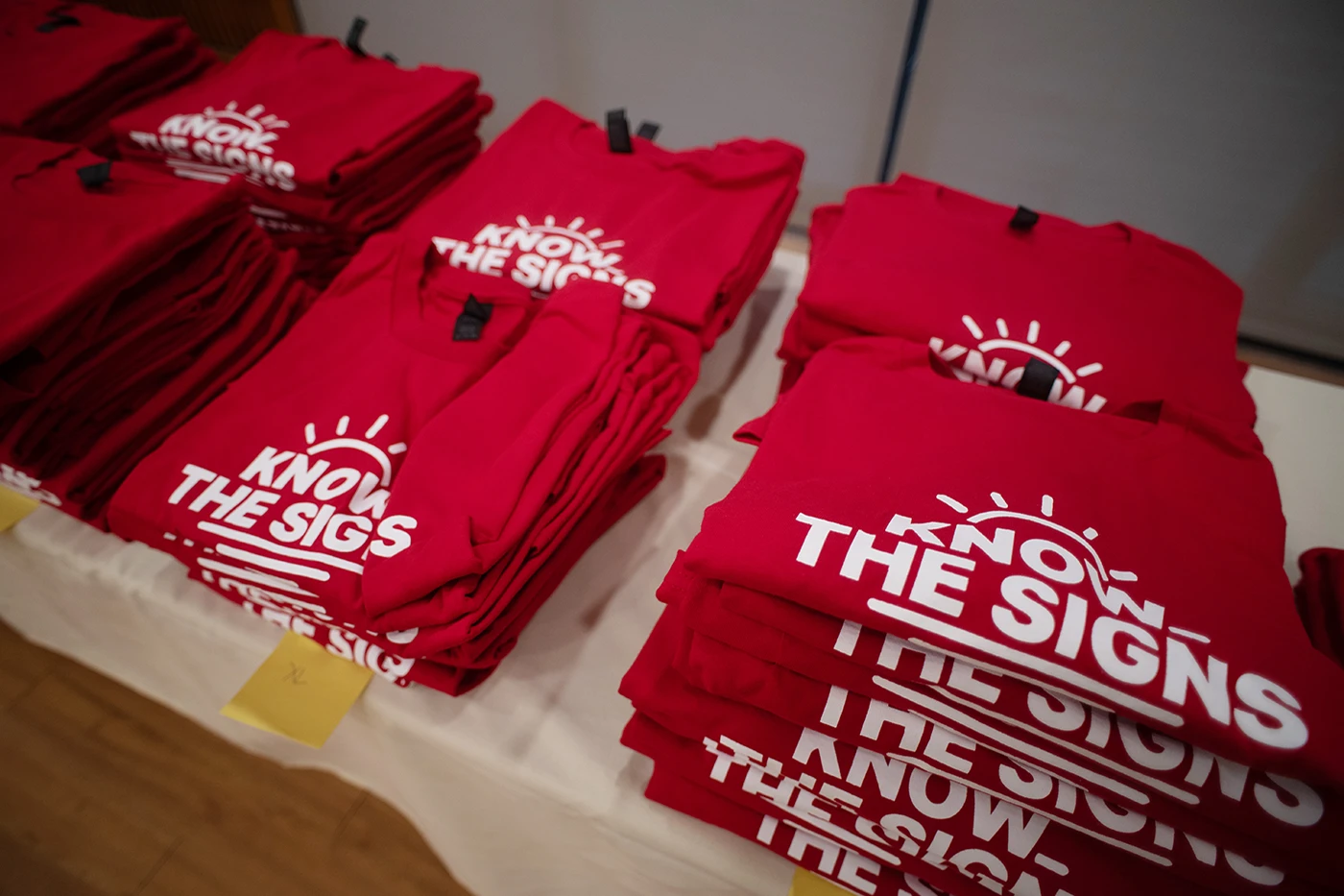 Red shirt with white letters that read 'Know The Signs'