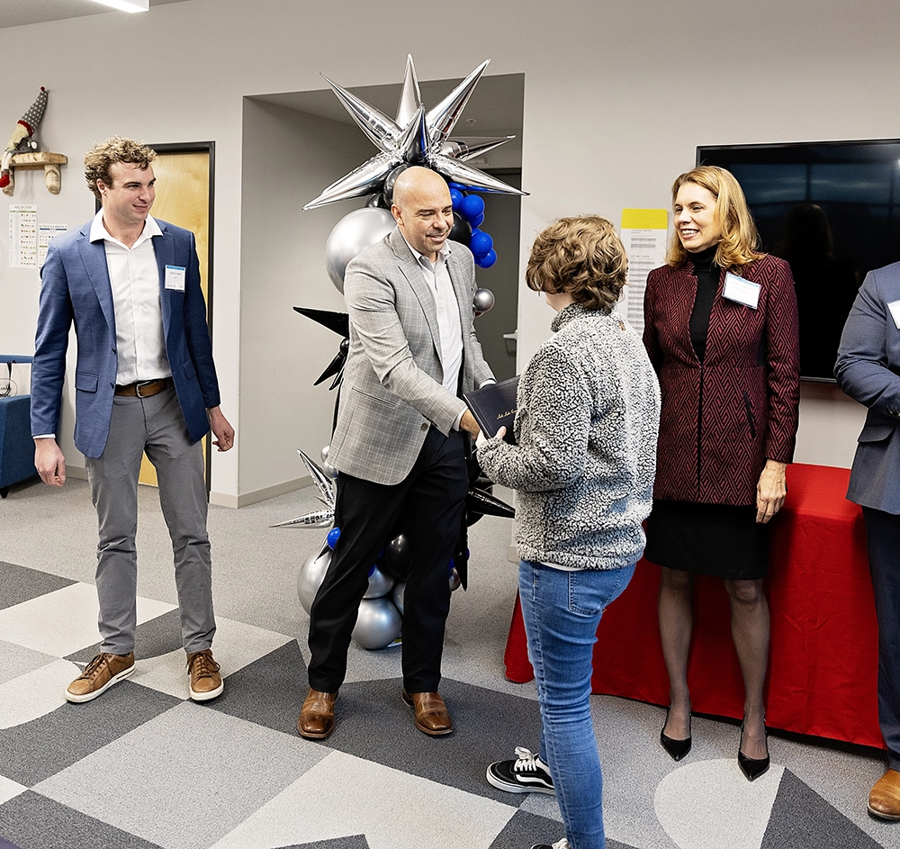 : Students pose for a group graduation photo on Dec. 19, 2025 at the Columbus Community Center. 