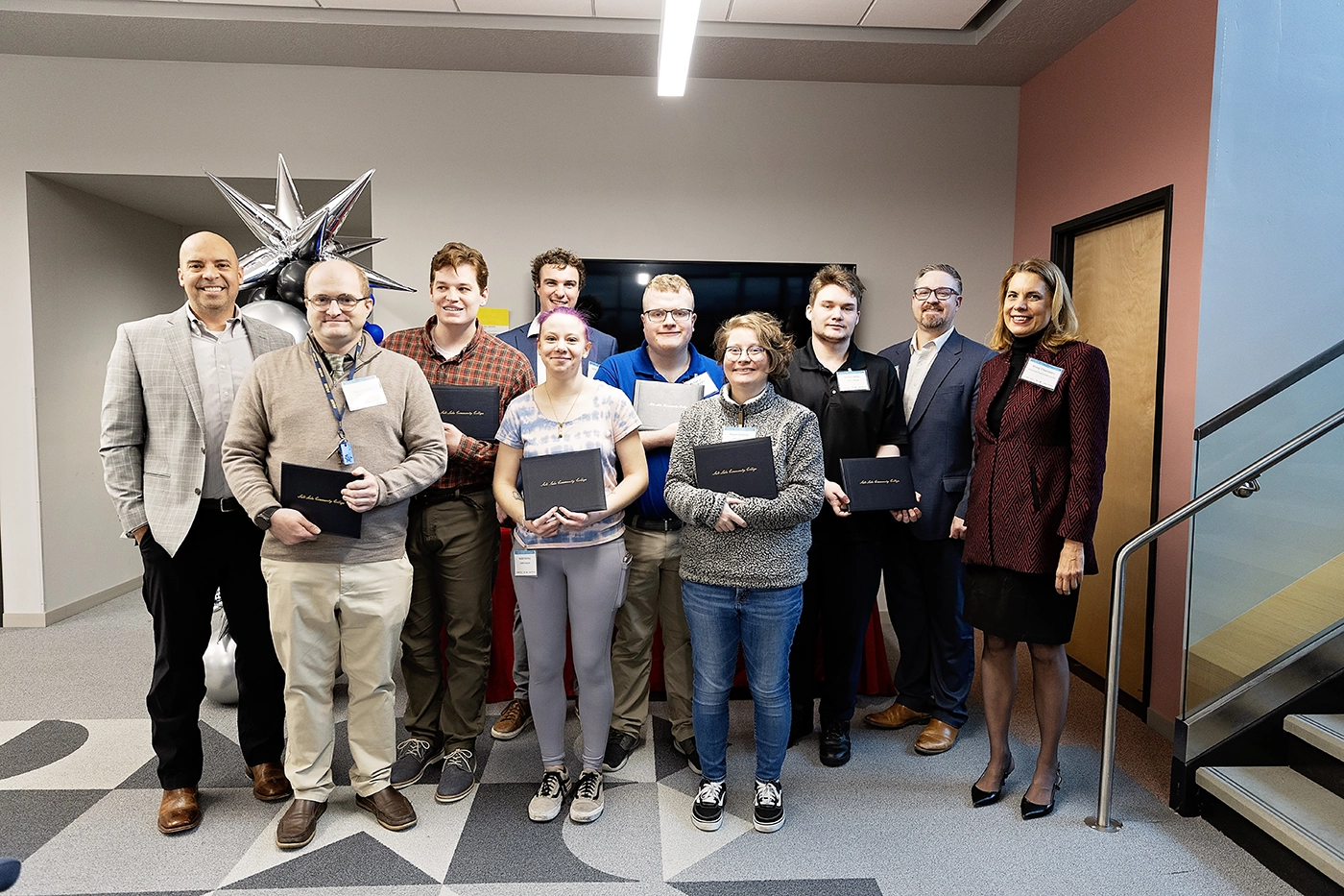 : Students pose for a group graduation photo on Dec. 19, 2025 at the Columbus Community Center. 