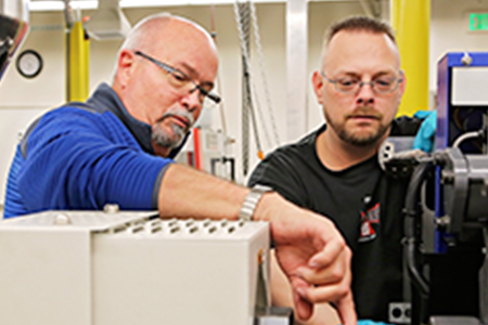 two guys working on a machine
