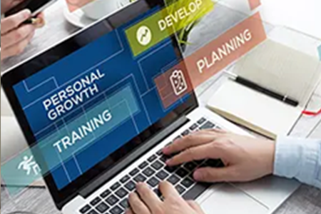 a woman with headphones doing homework on her laptop